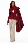 Woman wearing a wine blazer with a scarf-inspired collar detail.