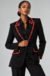 Close view of a women's blazer with decorative bead embellishment.